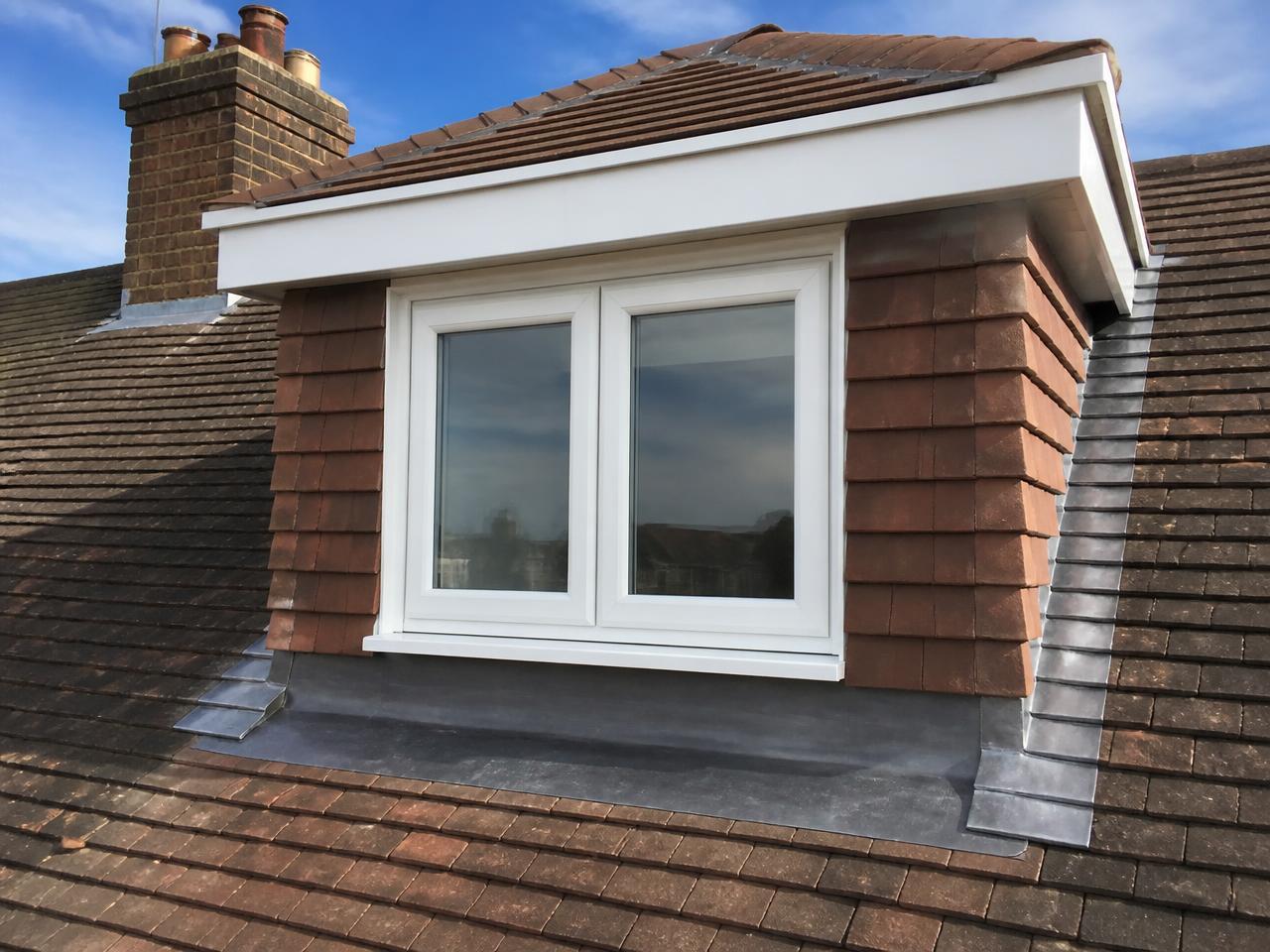 A dormer window with tile-hung cheeks and neatly dressed lead on a pitched roof